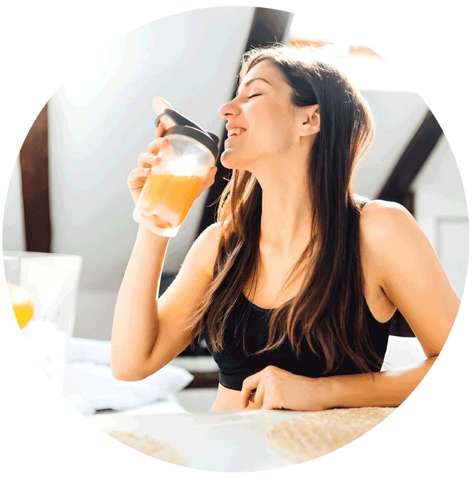 Smiling woman drinking orange juice, the vitamin boost of the Immune Boost IV drip in Bali