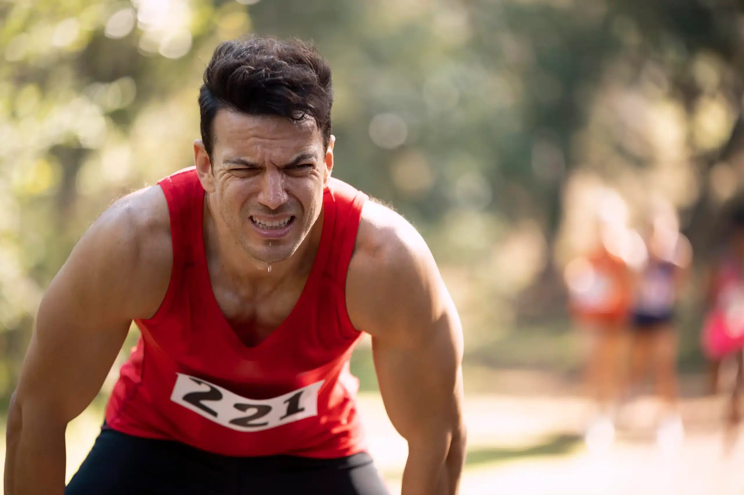 Exhausted runner catching his breath after a race, in need of an athlete recovery IV drip in Bali